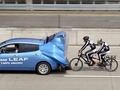 Tandem kerékpárosok a Nissan Leaf szélárnyékában